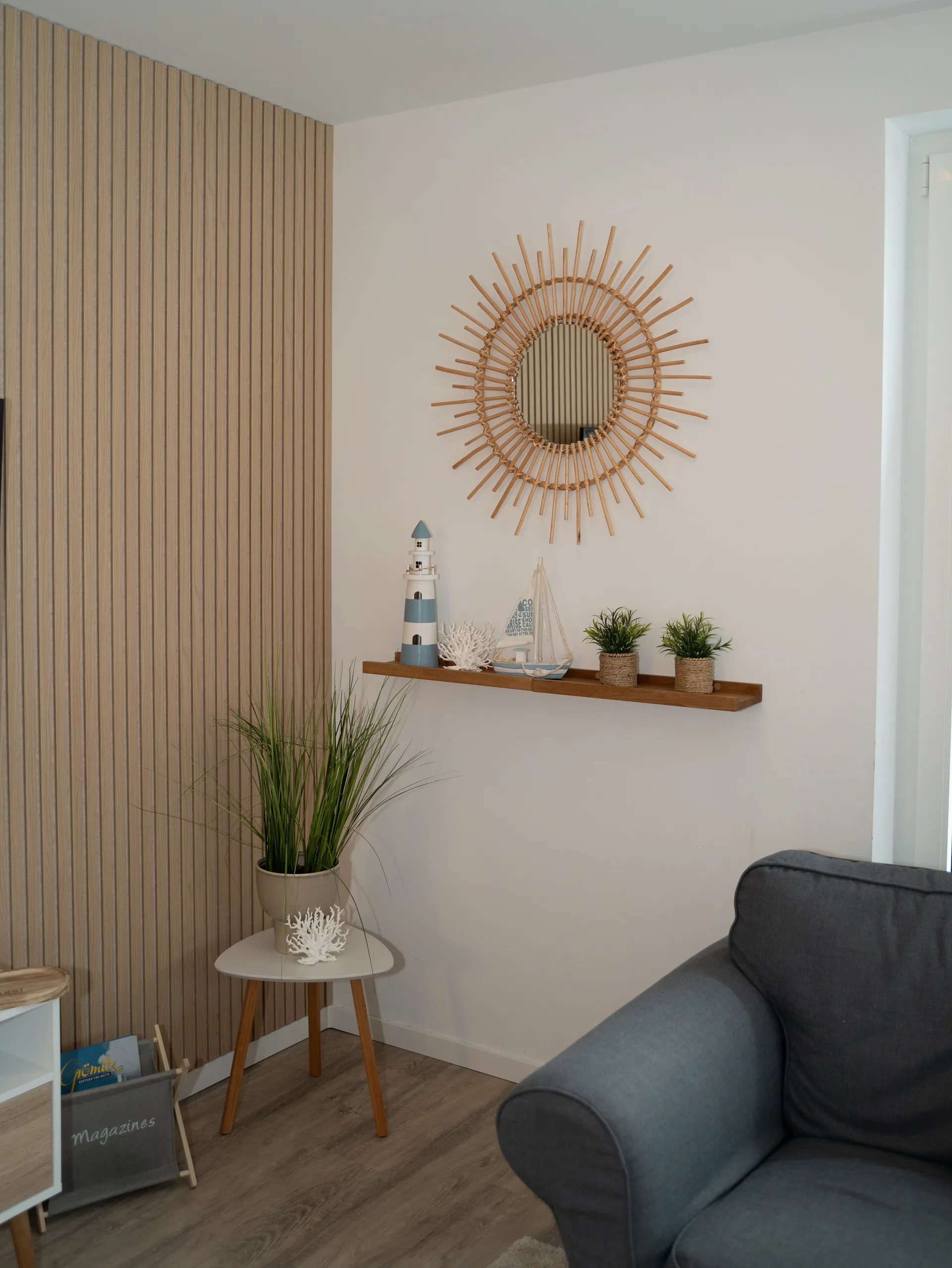 Sonnenspiegel und Leuchtturm-Dekoration im Wohnzimmer der Ferienwohnung Kurparkperle Grömitz